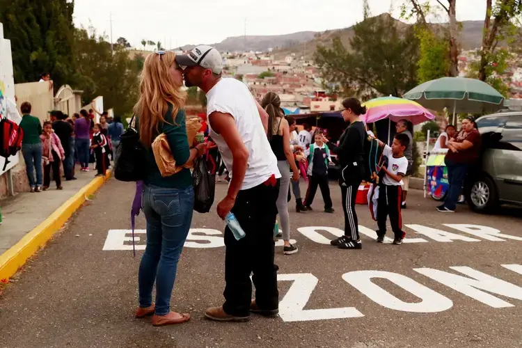 Joy and Rafael share a kiss while picking up the kids from school. Image by Erika Schultz. Mexico, 2019. 