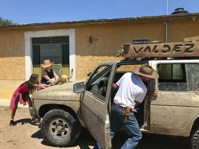 Maya, Joy and Rafael Valdez push their SUV to get it started after the battery died. They use the vehicle in the countryside while sharing the roads. Image by Nina Shapiro. Mexico, 2019.