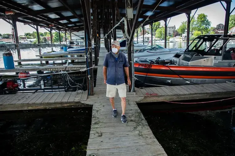 Navy Point Marine co-owner Peter Leubner walks his docks at Sackets Harbor, New York, on July 31, 2020. In 2017, he said, he was forced to shut down the power to the marina as waves crashed in and 35 boat slips were lost. Image by Zbigniew Bzdak/Chicago Tribune. United States, 2020.<br />
