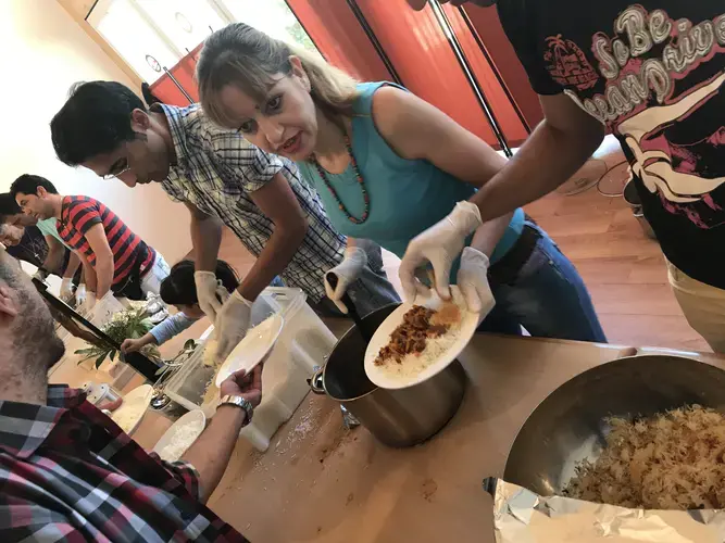 Members of a church in southern Berlin serve Iranian stew after Sunday service to a congregation of moslty Iranian and Afghan converts. Image by Alice Su. Germany, 2017.