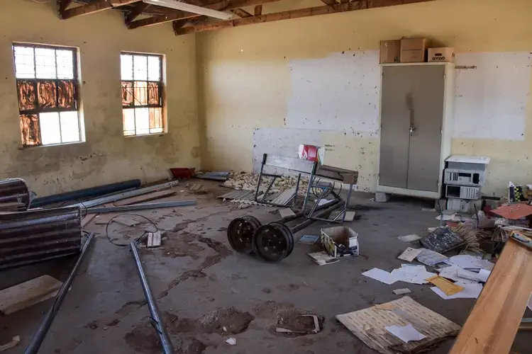 A classroom that was abandoned due to its crumbling infrastructure now serves as a storage room. Image by Adam Yates. South Africa, 2018.