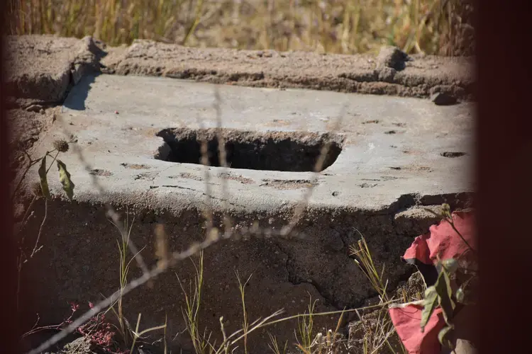 A pit toilet at Utjane that is no longer in use due to the danger it posed to learners. The school built a fence in front of the toilet to prevent young students from accessing it. Image by Adam Yates. South Africa, 2018.