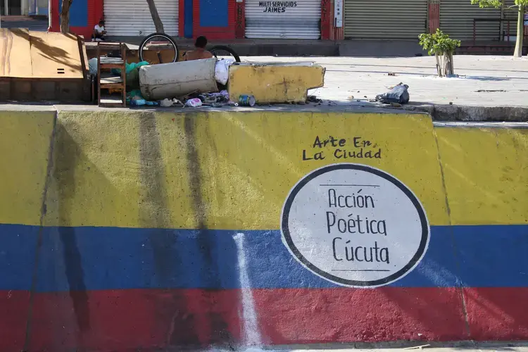 A homeless man has made a mural his place of rest in Cucuta. Image by Mariana Rivas. Colombia, 2019.