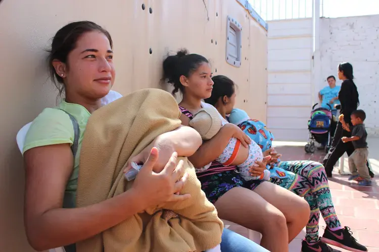 Venezuelan mothers wait to vaccinate their babies at a humanitarian clinic in La Parada, Cucuta, Colombia. Many new mothers regularly make the journey to Colombia to seek medical treatment. Image by Mariana Rivas. Colombia, 2019.