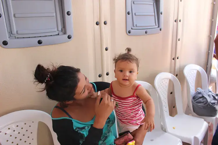 Nieto holds her daughter Juli, 7-months, who was born stateless in Colombia. Image by Mariana Rivas. Colombia, 2019.