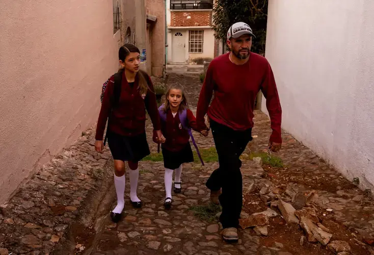 Rafael walks Maya and Catalina to school. The girls have lived in Mexico and the U.S. and have dual citizenship. Image by Erika Schultz. Mexico, 2019. 