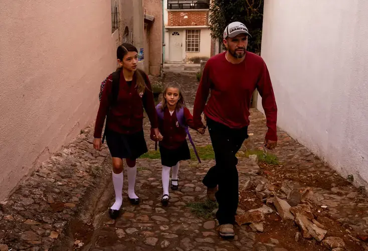 Rafael walks Maya and Catalina to school. The girls have lived in Mexico and the U.S. and have dual citizenship. Image by Erika Schultz. Mexico, 2019.