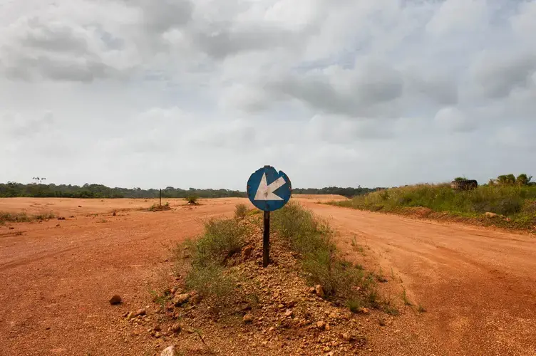 Red bauxite roads run for miles around the shuttered mining and mill operations that once made Suralco one of Suriname's largest employers. The company, a subsidiary of Alcoa, has promised to remediate the land. Image by Stephanie Strasburg. Suriname, 2017.<br />
