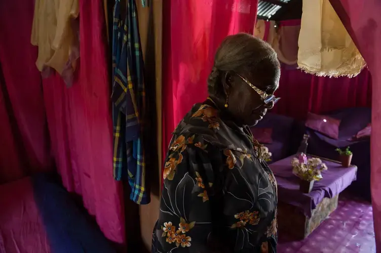 Georga Burger in the one room house in New Ganze, Suriname she was relocated to when her village was flooded to provide water for the Afobaka Dam. Burger left with her children as the water rose around her old house, leaving many of her belongings and animals. Image by Stephanie Strasburg. Suriname, 2017.