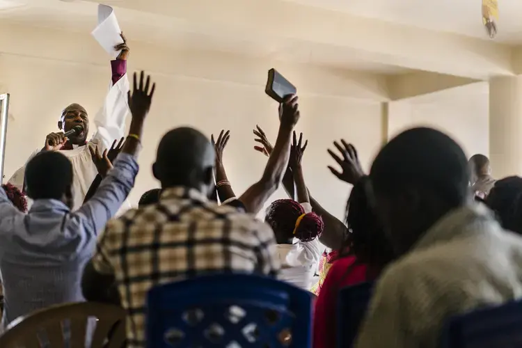 Members of the LGBT community, allies and others gather for a church service led by gay, black American pastor Joseph Tolton. Tolton comes to East Africa several times a year to mentor local pastors in 'radical inclusivity' and to be more welcoming to the LGBT community. He and others like him are in some ways the anti-Scott Lively. Image by Jake Naughton. Uganda, 2017.