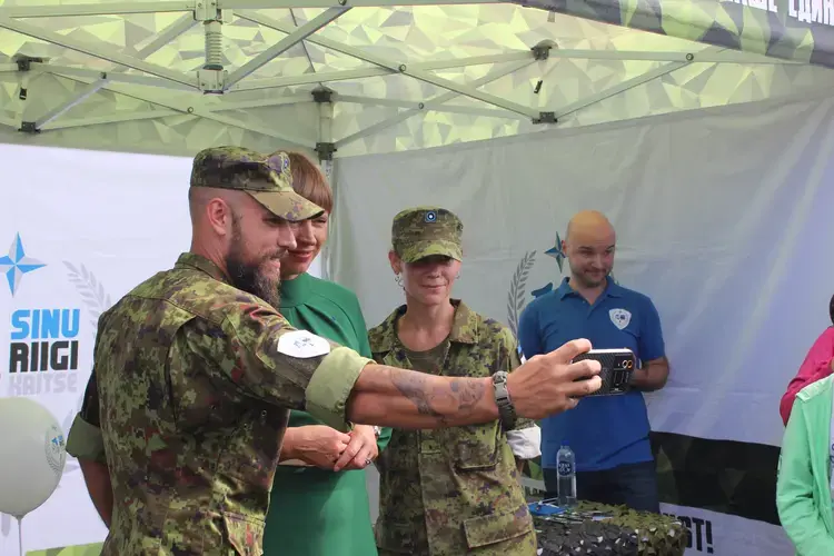 The Estonian president posing for a selfie with Estonian soldiers in Tallinn on Independence Restoration Day. Image by Hani Zaitoun. Estonia, 2019.