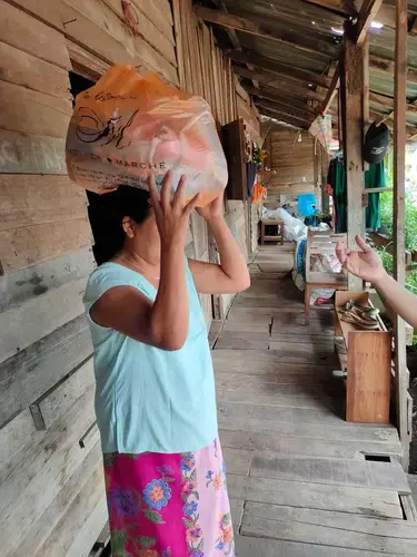 A woman holds food that has been delivered to her. Image courtesy of Hmine. Thailand, 2020.