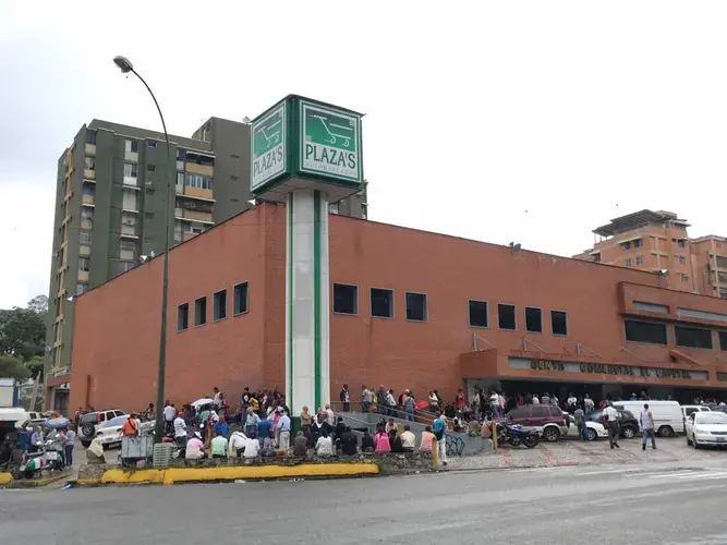 Long line of people wait to enter Plaza Supermarket . Image by María González. Venezuela, 2017.