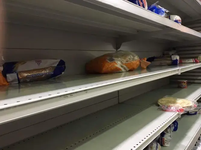 Empty food shelves inside Plaza Supermarket. Image by María González. Venezuela, 2017.