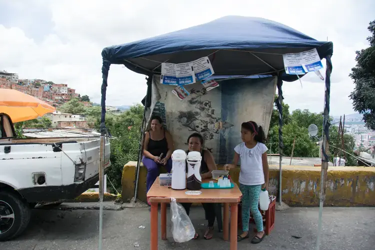 A woman sells coffee by the side of the street. Image by Horacio Siciliano. Venezuela, 2017.