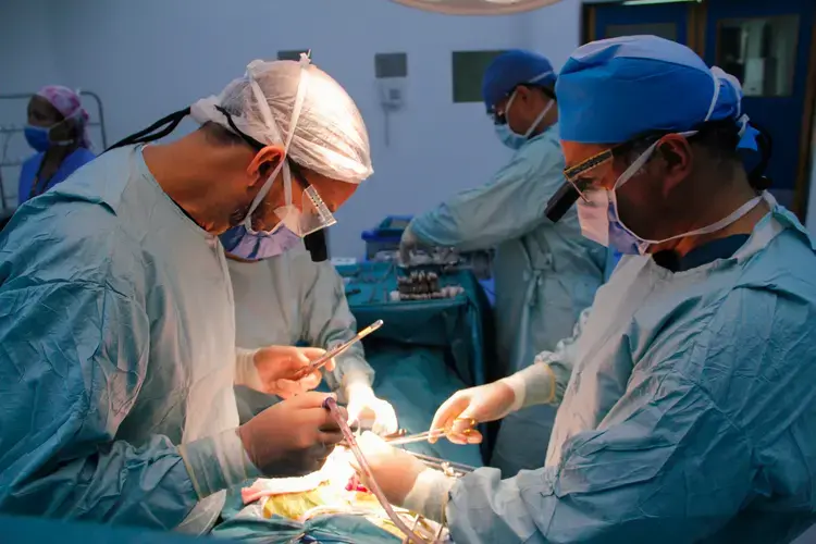 Leading surgeons Pedro Rivas (left) and Carlos Rodríguez (right) perform a kidney transplant at the private hospital Clínica Metropolitana, in Caracas. Image by Flaviana Sandoval. Venezuela, 2018.