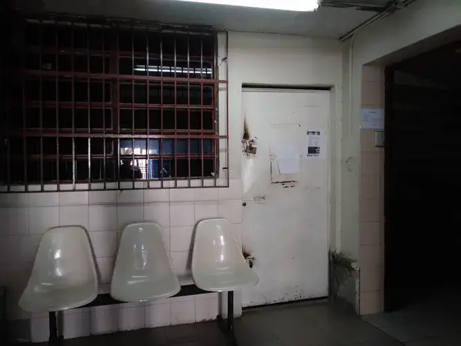 The waiting room at Clinica Riverside, in East Caracas, where Carlos Román receives dialysis three times a week, is a dark room with dim white light and rusty white metal chairs. Family members and visitors are not allowed inside the dialysis unit and must wait outside until the patient's session is finished.