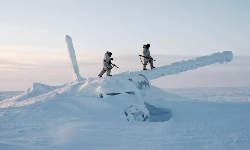 Canadian Arctic operations advisers scale the decades-old wreckage of an airplane in temperatures below -50C. They are on reconnaissance outside Resolute Bay on Cornwallis Island, Nunavut, Canada. Image by Louie Palu / Zuma Press. Canada, undated.