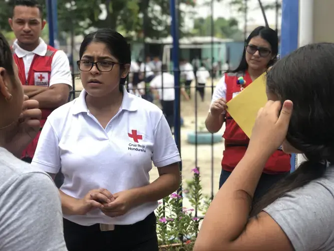 The Honduran Red Cross helps kids affected by migration. Here, Karen Martinez talks with a student. Image by Jaime Joyce. Honduras, 2019.