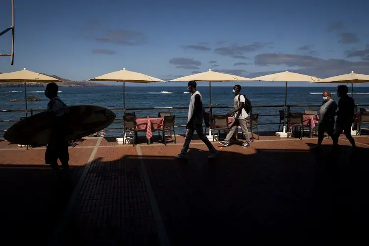 Asylum-seekers Kassim Diallo and Yamadou Konaré of Mali walk next to the beach in Las Palmas de Gran Canaria, Spain, on Thursday, Aug. 20, 2020. Image by Emilio Morenatti/AP Photo. Spain, 2020.
