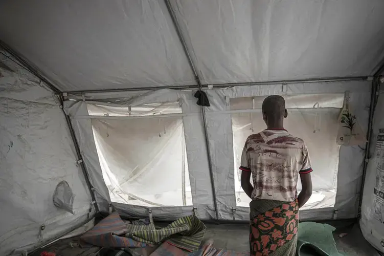 15-year-old Nogos stands in a tent at the '22nd May Stadium' where he took shelter with other migrants, in Aden, Yemen. Image by AP Photo/Nariman El-Mofty. Yemen, 2020.