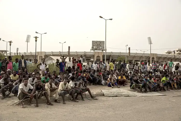 Ethiopian migrants take shelter in the '22nd May Soccer Stadium,' destroyed by war, in Aden, Yemen. Image by AP Photo/Nariman El-Mofty. Yemen, 2020.