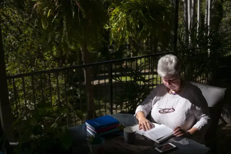 Deb Ware logs an entry in her diary at her home in Fountaindale, Central Coast, Australia, Friday, July 19, 2019. Image courtesy of David Goldman. Australia, 2019. 
