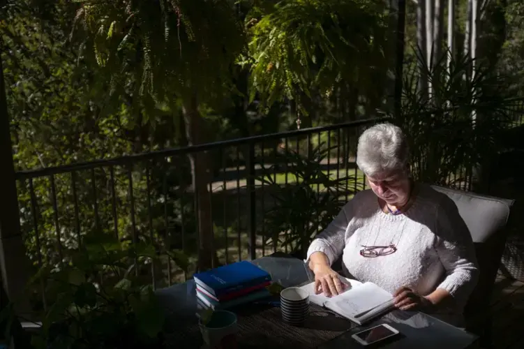 Deb Ware logs an entry in her diary at her home in Fountaindale, Central Coast, Australia, Friday, July 19, 2019. Image courtesy of David Goldman. Australia, 2019.