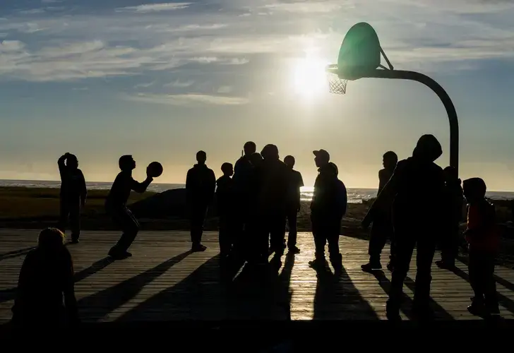 Children on Shishmaref play basketball late in the evening on the village's playground. Image courtesy of Nick Mott. United States, 2018.