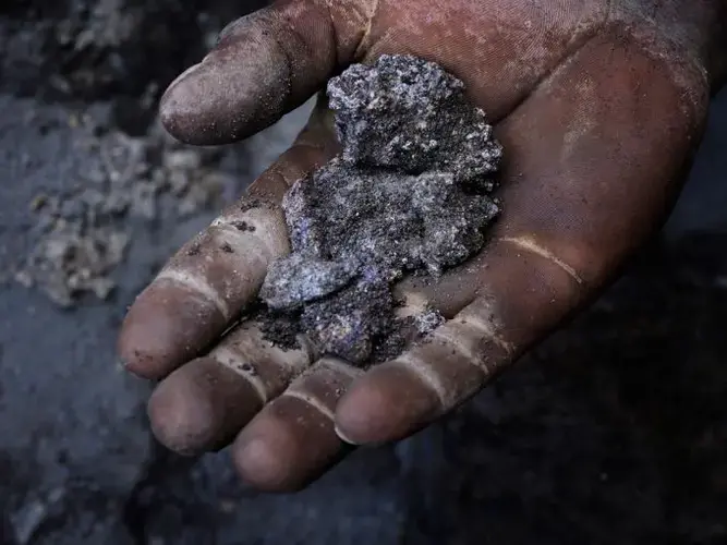 The payoff: A fistful of lead scraps. The lead-rich ore is collected, bagged, and sold to recyclers. In turn, the slag is sent to distant African smelters for processing into pure lead. Image by Larry C. Price. Zambia, 2017.