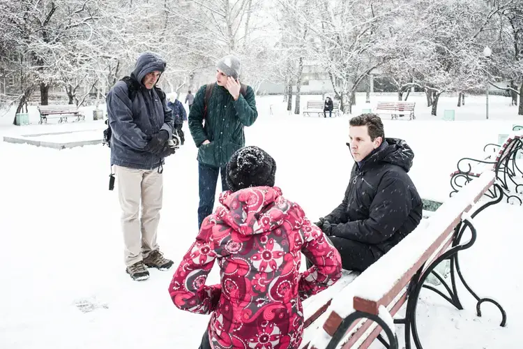 As Science magazine's Jon Cohen (hood) and interpreter Dmitrii Bezouglov look on, PBS NewsHour's William Brangam (seated) interviews a woman in Yekanterinburg, Russia, who was forcibly locked up in a drug-rehab center that lawsuits subsequently shut down. Image by Misha Friedman. Russia, 2017.</p>
<p>