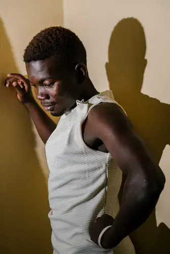 Hajjati, 22, a transgender woman and the executive director of Rainbow Mirrors Uganda, poses for a portrait in the RMU offices. Image by Jake Naughton. Uganda, 2017.