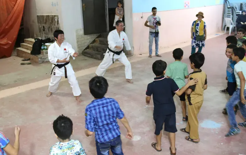 Children relieve stress at Homs League Abroad with various activities. Here they are practicing karate moves with a Japanese volunteer team. Image by Sawsan Morrar. Jordan, 2017.