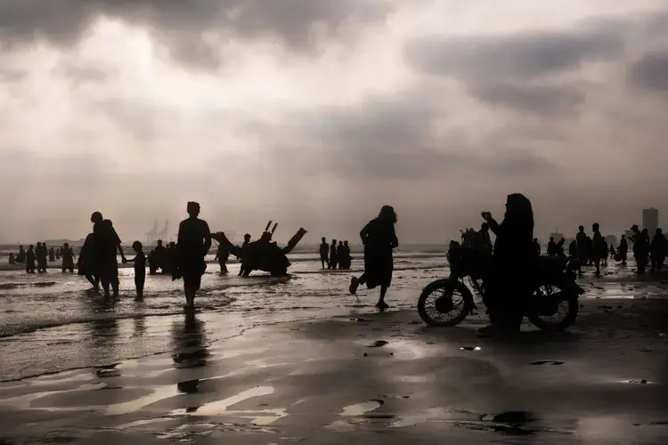 Religious differences vanish as Christians, Shiites, Sunnis, and Ahmadis congregate at sunset in the Arabian Sea. Image by Monika Bulaj. Pakistan, 2018.