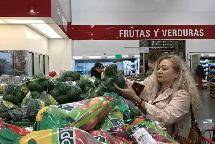 Enedis Flores searches for the best avocados to make guacamole for her family’s Thanksgiving dinner while shopping with her son, Raymond, at a Tijuana Costco on Nov. 28. Long checkout lines awaited the pair at the store even though Thanksgiving is an American holiday not widely celebrated in Mexico. Image by Amanda Cowan. Mexico, 2019.