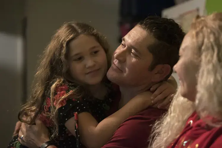 Rayma Flores spends a happy moment with her father, Ramon, and mother, Enedis, after Thanksgiving dinner. Rayma and her siblings can only see their father on the weekends in Tijuana, Mexico, because he was deported from the United States in August 2017. Image by Amanda Cowan. Mexico, 2019.