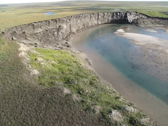 A cliff of icy permafrost is seen along the Itkillik River in northern Alaska. It is being eroded by the river. Image courtesy of Mikhail Kanevskiy. United States, 2019.