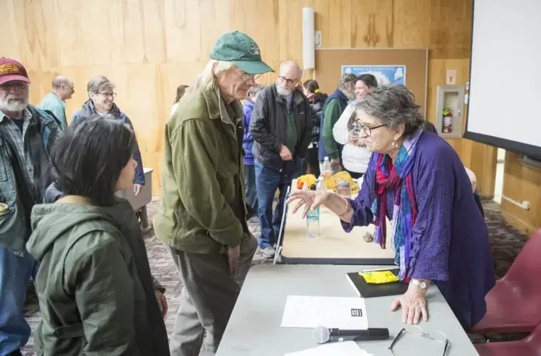 Duane Hanson, left center, meets with Roberta Benefiel-Frampton, right, director of the Grand River Keepers in Happy Valley-Goose Bay, Labrador, after a panel discussion on the negative impacts of HydroQuebec and Nalcor in Labrador at Preble Hall at the University of Maine in Farmington on Nov. 25, 2019. Image by Michael G. Seamans. United States, 2019.