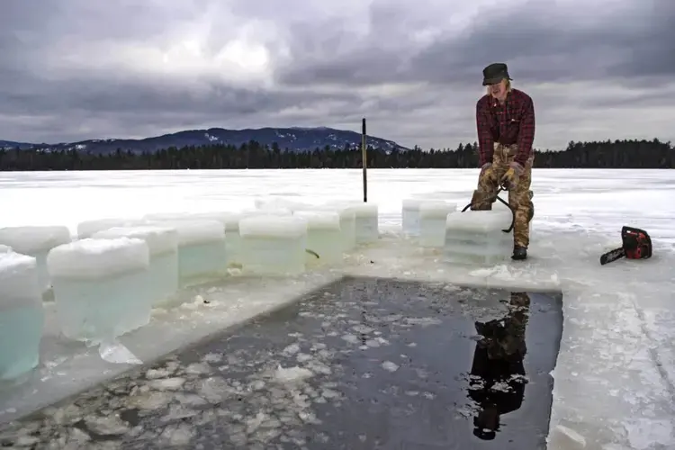 Duane Hanson hauls 16-inch square blocks of ice from his pond in T5 R7 in the Unorganized Territories on Jan. 4, 2020. The ice will be stored in an ice house with saw dust to be used to refrigerate food throughout the year. Image by Michael G. Seamans. United States, 2019.
