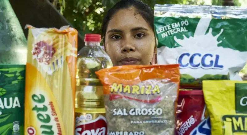 Joane with products from her village wrapped in plastic. Image by Pablo Albarenga. Brazil, 2019.