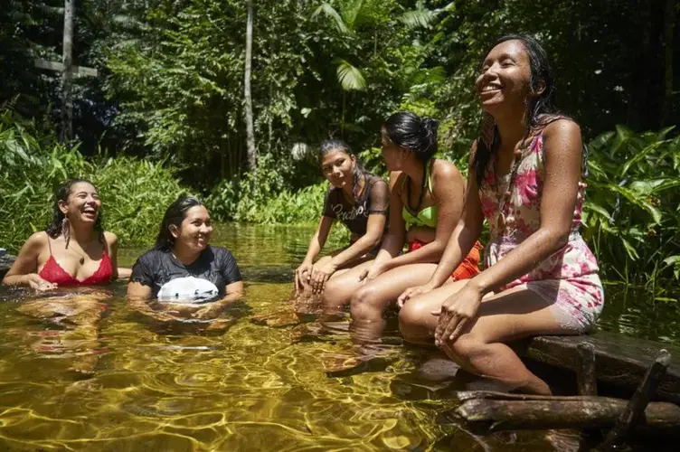 Tupi talks to her friends whilst they bathe in the river. Image by Pablo Albarenga. Brazil, 2019.