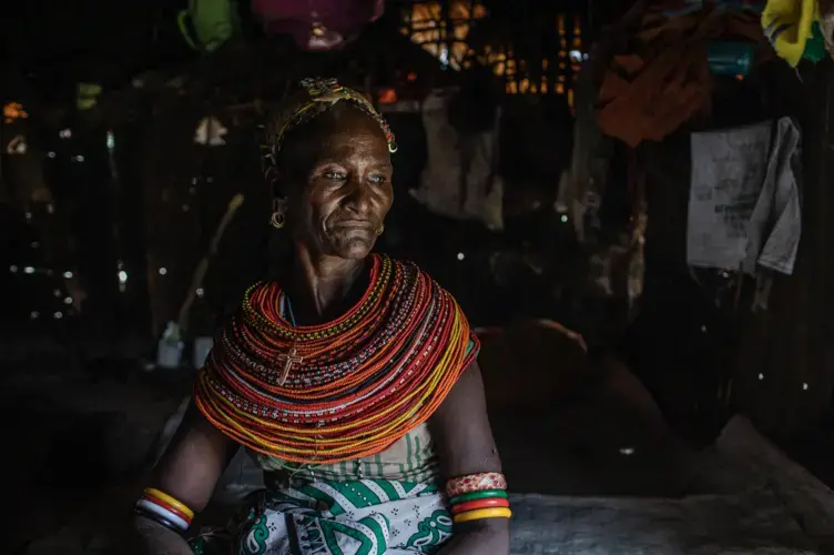 Christine Lemowonapi, a former Rendille circumciser, sits inside her home in Merille, Kenya. She has lost her source of income since the government outlawed the practice. Image by Will Swanson. Kenya, 2020.