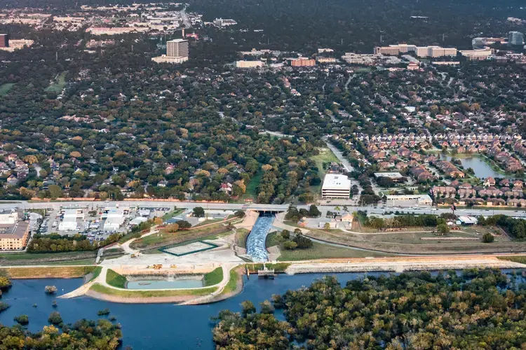Barker Reservoir, looking from the reservoir toward the city. It shows how flooded it is, a month after the storm and how it’s outlet, the continuation of Buffalo Bayou flows right through very dense areas. Image by Alex MacLean. United States, 2018.