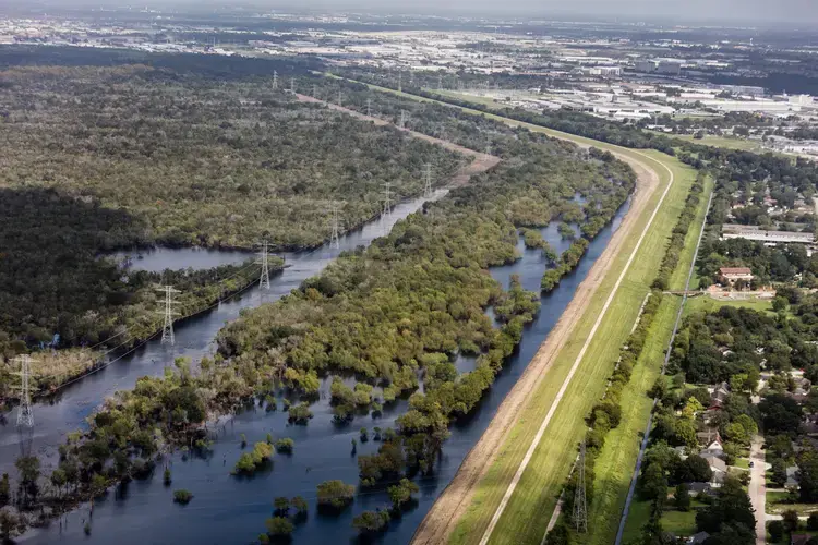 Addicks Reservoir, one of two basins – along with Barker Reservoir – that together protect downtown Houston. Together they hold 500 million cubic metres of water. The recordbreaking rainfall pouring into Buffalo Bayou, which feeds the reservoirs, pushed the water level higher than it had ever reached. Homeowners upstream, discovered to their surprise that their land was in the basin. Their houses were flooded, in some cases requiring major repairs. Water officials eventually opened gates, letting water rush out of Addicks into downstream reaches of Buffalo Bayou, flooding homes there as well. Image by Alex MacLean. United States, 2018.