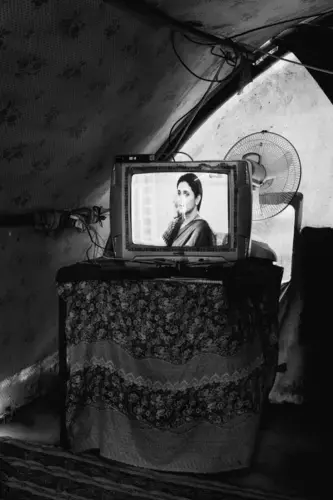 In a camp outside Qayyarah, internally displaced Iraqis watch Indian soap operas. Image by Moises Saman / Magnum for The New Yorker. Iraq, 2018.