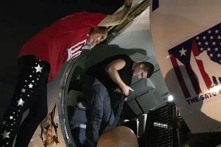 Beckles leans into the plane as the final crates are loaded in. Image by Jamie Holt. United States, 2019.<br />
