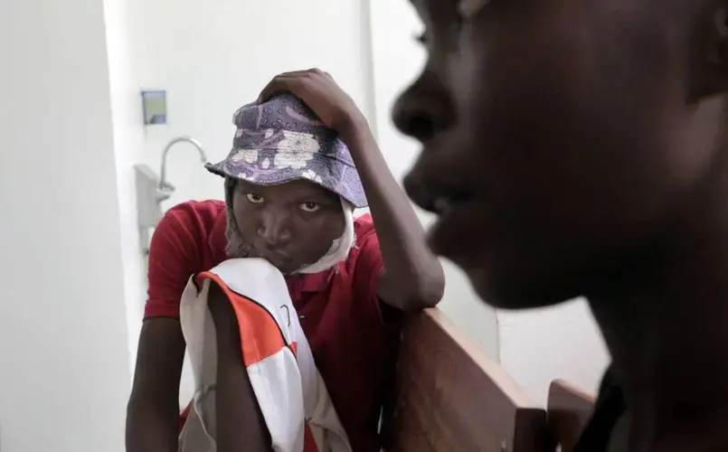 A dejected Djooly Jeune, 17, sits by his mother, Angena Altidor, after a nurse at the University Hospital of Mirebalais finally informs them that he would not be able to get his chemotherapy because of his blood work. Image by José A. Iglesias. Haiti, 2018. 