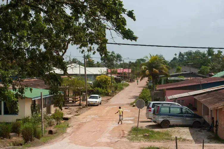 A man walks through a neighborhood in Moengo, Suriname, built by Alcoa's subsidiary for its employees. Image by Stephanie Strasburg. Suriname, 2017.<br />