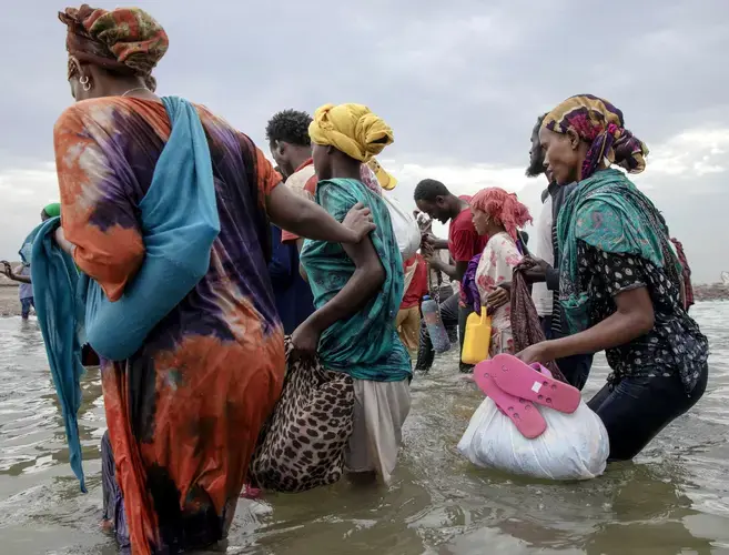 Ethiopian migrants disembark from a boat on the shores of Ras al-Ara, Lahj, Yemen. Image by AP Photo/Nariman El-Mofty. Yemen, 2020.