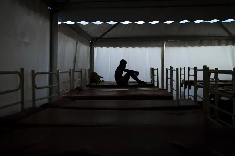 Mamadou Patherazi, from Guinea, sits on a bunk bed of the Modern Christian Mission Church in Fuerteventura, one of the Canary Islands, Spain, on Saturday, Aug. 22, 2020. Image by Emilio Morenatti/AP Photo. Spain, 2020.